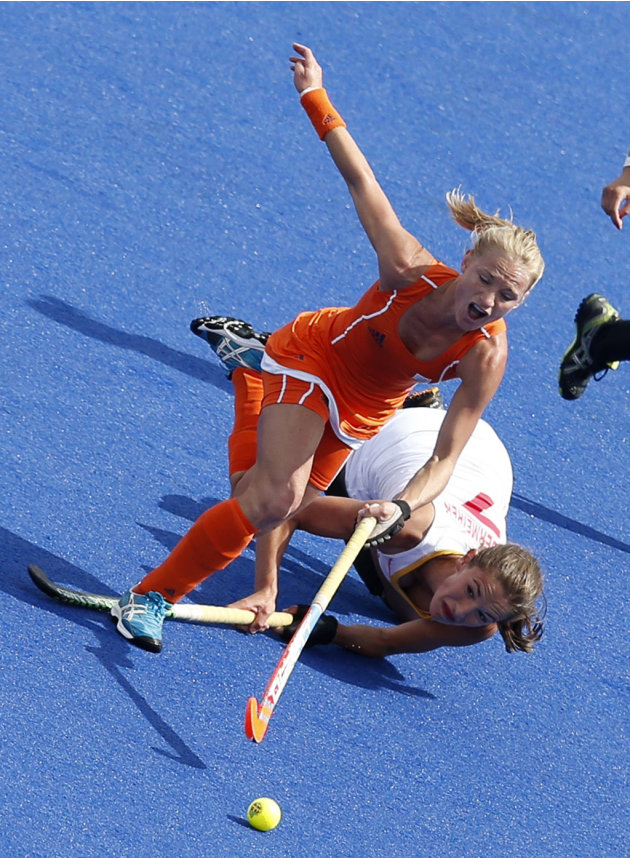 Netherlands&#39; Maartje Goderie challenges Belgium&#39;s Judith Vandermeiren for the ball during their women&#39;s Group A hockey match at the London 2012 Olympic Games at the Riverbank Arena on the 