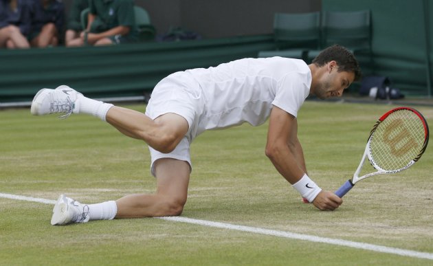 Grigor Dimitrov of Bulgaria slips in his men's singles tennis match against Grega Zemlja of Slovenia at the Wimbledon Tennis Championships, in London