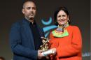 Moroccan director Mohamed Mouftakir (L) receives from Tunisian Culture Minister Latifa Lakhdar the Golden Tanit award for his film "L'orchestre des aveugles" during the 26th Carthage Film Festival on November 28, 2015 in Tunisian capital Tunis