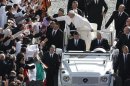 Papa Francesco su un'auto aperta accarezza una bimba tra la folla a San Pietro prima di iniziare la messa di intronizzazione del suo pontificato