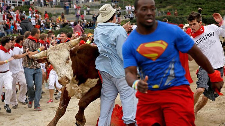 Participants are knocked over by charging bulls during the Great Bull Run at the Georgia International Horse Park, Saturday, Oct. 19, 2013, in Conyers, Ga. The event, expected to attract 3,000 runners Saturday, is inspired by the annual running of the bulls in Pamplona, Spain and has future stops planned in Texas, Florida, California, Illinois and Pennsylvania. (AP Photo/David Goldman)