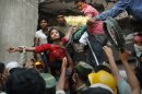 A Bangladeshi woman survivor is lifted out of the rubble by rescuers at the site of a building that collapsed Wednesday in Savar, near Dhaka, Bangladesh, Thursday, April 25, 2013. By Thursday, the death toll reached at least 194 people as rescuers continued to search for injured and missing, after a huge section of an eight-story building that housed several garment factories splintered into a pile of concrete.(AP Photo/Kevin Frayer)