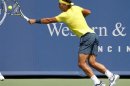 Rafael Nadal hits a return ball to John Isner during their championship match at the men's Cincinnati Open tennis tournament