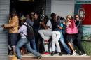 Students demanding free education react as they are fired at by riot police officers during a protest outside the University of the Witwatersrand at Braamfontein, in Johannesburg, South Africa