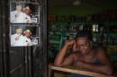 A woman on April 1, 2015 in her shop next to campaign posters of former Nigerian President Goodluck Jonathan, in Otuoke