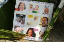 A note on the sidewalk includes photos of the nine who were killed at a memorial in front of the Emanuel AME Church on Friday, June 19, 2015 in Charleston, S.C. Dylann Storm Roof, 21, is accused of killing nine people during a Wednesday night Bible study at the church. ( Curtis Compton/Atlanta Journal-Constitution via AP) MARIETTA DAILY OUT; GWINNETT DAILY POST OUT; LOCAL TELEVISION OUT; WXIA-TV OUT; WGCL-TV OUT