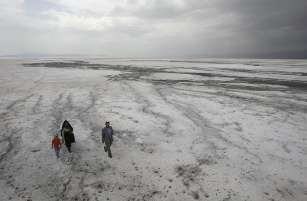 FILE - In this Friday, April 29, 2011 file photo, an Iranian family walk on the solidified salts of the Oroumieh Lake, Iran, as they sightsee the lake. Protesters demanding greater environmental prote