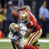 San Francisco 49ers quarterback Colin Kaepernick (7) tries to elude New Orleans Saints cornerback Leigh Torrence (24) during the first half of an NFL preseason football game at the Louisiana Superdome in New Orleans, Friday, Aug. 12, 2011. (AP Photo/Bill Feig)