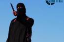 An image grab taken from a video released by the Islamic State group and identified by private terrorism monitor SITE Intelligence Group on September 13, 2014 purportedly shows a masked militant holding a knife and gesturing as he speaks
