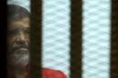 Egypt's ousted Islamist president Mohamed Morsi looks on from behind the defendant's bars during his trial on espionage charges at a court in Cairo on June 18, 2016