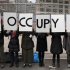Protesters affiliated with the Occupy Wall Street movement stand with signs outside Duarte Square in New York