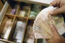 A teller counts euro banknotes inside a National Bank of Greece branch in Athens