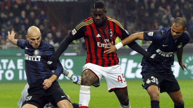 AC Milan's Mario Balotelli (C) fights for the ball with Inter Milan's Esteban Cambiasso (L) and Rolando during their Italian Serie A soccer match at San Siro stadium in Milan December 22, 2013. REUTERS