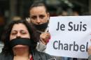 Supporters of Lebanese satirist Charbel Khalil cover their mouths with black cloth and hold a French placard that reads: "we are Charbel," as they protest outside the judicial palace in Beirut, Lebanon, Monday, Feb 23, 2015. The Lebanese satirist has appeared before a prosecutor in Beirut after the country's top Sunni religious authority filed a judicial complaint against him for allegedly defaming Islam. Khalil found himself in hot water after he shared a photo on social media earlier this week that was viewed by some as insulting of Islam. (AP Photo/Hussein Malla)