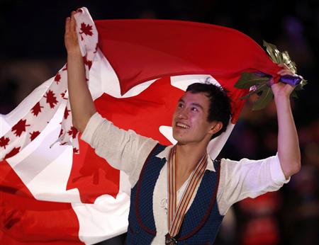 Patrick Chan of Canada carries his country's flag as he celebrates his gold medal finish after the medal ceremony at the ISU World Figure Skating Championships in London