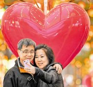 　　心心相印
　▲情人節周二登場，周末的台北街頭已經充滿了浪漫氛圍，一對男女享受情人節前的周末假期，在巨大的「愛心」前甜蜜自拍。（圖文：陳振堂）