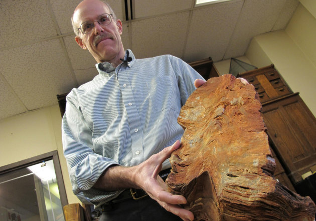 In this Jan. 22, 2013 photo University of Wisconsin-Madison Geoscientist Clark Johnson holds what he says is a 3.5 billion year old rock in Madison, Wis. Johnson is leading a team of scientists and others studying Earth rocks that are billions of years old looking for crucial information to understand how life might have arisen elsewhere in the universe and guide the search for life on Mars one day. (AP Photo/Carrie Antlfinger)