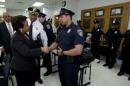 Attorney General Loretta Lynch shake hands with Baltimore police officers during a visit to the Central District of Baltimore Police Department