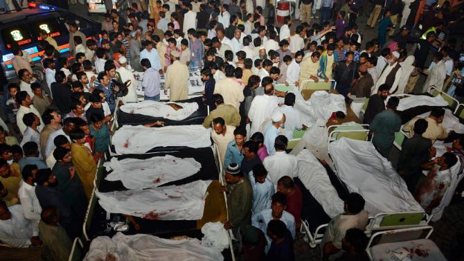 Pakistani relatives gather around the bodies of blast victims after a suicide bomb attack near the Wagah border on November 2, 2014