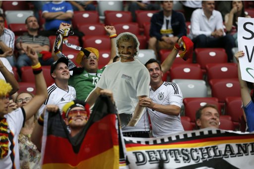 Fans of Germany's soccer team hold cut-out of former German striker and former national coach Voeller before Euro 2012 semi-final soccer match against Italy at National Stadium in Warsaw
