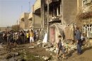 Residents inspect a destroyed building at the site of a bomb attack in Chukook district, in Baghdad
