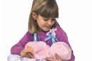 This product image released by Berjuan Toys shows a girl playing with The Breast Milk Baby doll. The breastfeeding doll, whose suckling sounds are prompted by sensors sewn into a halter top, has caught some flak after hitting the U.S. market. (AP Photo/Berjuan Toys)