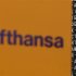 The Logo of German air carrier Lufthansa is pictured next to a departure board during a five-hour warning strike, following a pay dispute, represented by German united services union Ver.di at the Fraport airport in Frankfurt