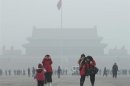 Turisti in piazza Tiananmen a Pechino, in mezzo allo smog