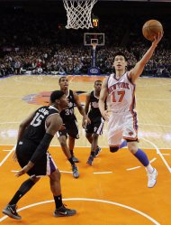 New York Knicks' Jeremy Lin (17) drives past Sacramento Kings' DeMarcus Cousins (15) during the second half of an NBA basketball game on Wednesday, Feb. 15, 2012, in New York. Lin had 10 points and 13 assists as the Knicks won the game 100-85. (AP Photo/Frank Franklin II)