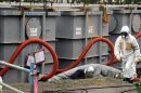 Un empleado de Tokyo Electric Power Company (TEPCO) pasa cerca de tanques llenos de agua radioactiva en la central nuclear de Fukushima (Japón). EFE/Archivo