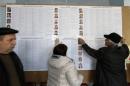 Election commission members prepare candidate information sheets at a polling station in the town of Slavyansk