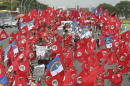 Demonstrators participate in a march organized by the Rural Workers Landless Movement or MST, most waving the red MST banners along with Brazilian national flags and Pernambuco state flags, in Brasilia, Brazil, Wednesday, Feb. 12, 2014. The MST, one of the globe's biggest agrarian reform movements, called the protest to demand that the government hand over more unused land to impoverished farmers who have none of their own. (AP Photo/Eraldo Peres)