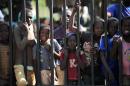 Children look through the gates of a camp for internally displaced persons set up at the airport in Bangui, on December 15, 2013