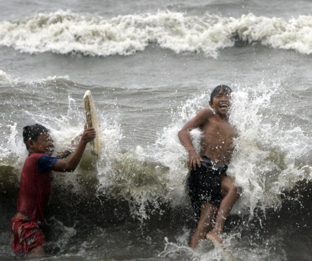 Two boys enjoy the surf due to Typhoon Nanmadol Saturday, Aug. 27, 2011 in Manila, Philippines. Forecasters said the typhoon hit the northeastern tip of the country with 121 miles (195 kilometers) per