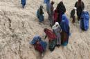 Displaced Afghans walks near the site of a landslide at the Argo district in Badakhshan province