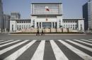 Policemen guard the entrance outside Shandong Province Supreme People's Court in Jinan, Shandong province