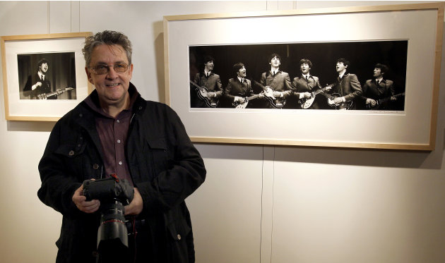 Photographer Mike Mitchell stands by some of his photographs of The Beatles where they are being exhibited at a hotel in London, Friday, June 10, 2011. The previously unseen photographs by US photogra