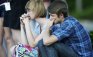 Melissa Clark, left, and Nathan Mendonca, both 18 and from Aurora, Colo., look on during a vigil across from the Century 16 theatre east of the Aurora Mall in Aurora, Colo., on Friday, July 20, 2012. Authorities report that 12 died and more than three dozen people were shot during an assault at the theatre during a midnight premiere of "The Dark Knight." (AP Photo/David Zalubowski)