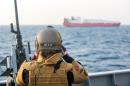 A handout picture taken on December 29, 2013, and released by Norwegian Armed Forces, shows a Norwegian officer on deck watching the cargo vessel "Taiko", earmarked to transport chemical agents from war torn Syria