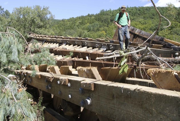 Teo Campbell stands on what used to be the bottom of the Bartonsville Covered Bridge over the Williams River, Monday, Aug. 29, 2011 in Rockingham, Vt . Heavy rains from Tropical Storm Irene tore the b