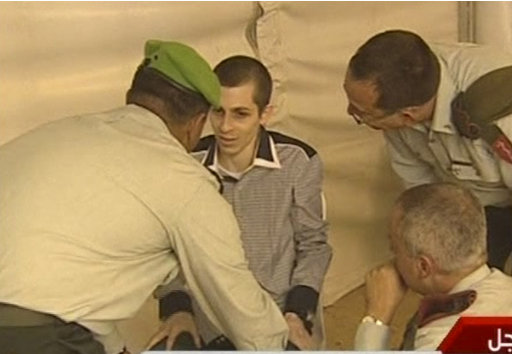 In this image from Egypt TV Tuesday Oct 18 2011 Israeli soldier Gilad Schalit is seen with unidentified military officials at Rafah Terminal on the Egypt- Gaza border.  Schalit was moved to Egypt from captivity in Gaza and then on to Israel an elaborate prisoner swap deal in which hundreds of Palestinian inmates are to be freed in return for the captured tank crewman who had been held by Hamas for over five years.  (AP Photo/ Egypt TV) TV OUT NO SALES