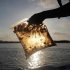 A man holds a plastic bag with oil from the Gulf of Mexico oil spill south of Freemason Island