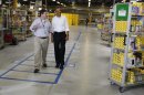 U.S. President Obama walks with Vice President of Worldwide Operations Clark as he tours the Amazon Fulfillment Center in Chattanooga