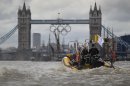 In this photo taken Wednesday, July 4, 2012, a high-speed 12-seater rigid inflatable boat, run by the Protection Services International company, travels towards Tower Bridge over London's river Thames, adorned with a huge Olympic rings to honor the games that will take place from July 27-Aug. 12. Companies like Protection Services International are just one of the many catering to the super rich who are coming to the London games and demand top security and easy transport. (AP Photo/Lefteris Pitarakis)