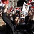 Mourners wave Syrian flags and a photo of President Bashar Assad as they chant slogans at a mass funeral Saturday, Dec. 24, 2011 for 44 people killed in twin suicide bombings that targeted intelligence agency compounds in Damascus, Syria. Mourners carried coffins draped in the red, white and black Syrian flags into the eighth-century Omayyad Mosque, where they were placed on the ground for prayers. (AP Photo/Muzaffar Salman)