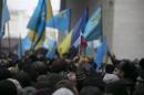 An ethnic Russian Ukrainian holds a Russian flag as Crimean Tatars rally near the Crimean parliament building in Simferopol