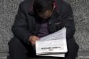 A Chinese man reads a newspaper which reports that U.S., Japan and South Korea sent flights through China's newly declared maritime air defense zone, in Beijing, China Friday, Nov. 29, 2013. China said it sent warplanes into the air defense zone days after the U.S., South Korea and Japan all sent flights through the airspace in defiance of rules Beijing says it has imposed in the East China Sea. (AP Photo/Andy Wong)