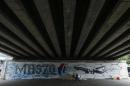 A man walks past graffiti of the missing Malaysia Airlines Flight MH370 in Kuala Lumpur