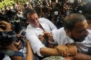 Bollywood actor Sanjay Dutt is escorted by his security staff as he arrives to surrender at a court in Mumbai