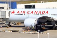 An Air Canada Boeing 777 sits at a gate after it was forced to return to Sydney Airport in Sydney, Thursday, July 28, 2011, after crew members saw smoke coming from an oven in the galley. No one on Flight AC34 was injured in the incident, which forced the pilot to dump fuel before safely landing. (AP Photo/Rick Rycroft)